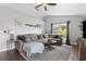 Inviting living room features a plush sectional sofa, ceiling fan and a stylish coffee table on a patterned rug at 1616 Golden Poppy Ct, Orlando, FL 32824