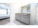 Bright bathroom with double vanity, granite countertop, and view to the main bedroom at 1791 Hackberry St, Clermont, FL 34715