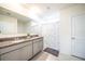 Well-lit bathroom with double vanity, granite countertop, and shower with decorative curtain at 1791 Hackberry St, Clermont, FL 34715