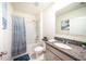 Well-lit bathroom featuring a shower-tub combo and granite countertop vanity at 1791 Hackberry St, Clermont, FL 34715