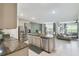 Open-concept kitchen featuring stainless steel appliances, granite countertops, and seamless flow to living area at 1791 Hackberry St, Clermont, FL 34715
