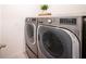 Modern stainless steel washer and dryer units with decorative plant on top at 1791 Hackberry St, Clermont, FL 34715