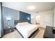 Stylish main bedroom with striped accent wall, modern furniture, and ensuite bathroom at 1791 Hackberry St, Clermont, FL 34715