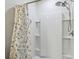 Modern bathroom shower featuring a curved, white shower surround and a leaf-patterned curtain at 1791 Hackberry St, Clermont, FL 34715