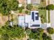 Beautiful home featuring a screened-in pool, solar panels, lush greenery, and mature trees at 1872 Wayside Dr, Orlando, FL 32818