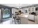 View of eat-in kitchen with center island, white cabinetry, and access to outdoor pool and patio at 1872 Wayside Dr, Orlando, FL 32818