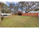 Large backyard with a brick fence and mature trees at 1913 Lazy Oaks Loop, St Cloud, FL 34771