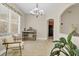 Bright dining area features an elegant chandelier, decorative shelving, and a comfortable chair by the window at 1913 Lazy Oaks Loop, St Cloud, FL 34771