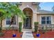 Close up of a home's entryway featuring a glass front door, potted plants, and mulch landscaping at 1913 Lazy Oaks Loop, St Cloud, FL 34771