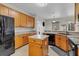 Well-equipped kitchen featuring an island, granite countertops, wooden cabinets, and stainless steel appliances at 1913 Lazy Oaks Loop, St Cloud, FL 34771