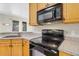 Kitchen with wood cabinetry, granite counters, and modern appliances offers style and functionality at 1913 Lazy Oaks Loop, St Cloud, FL 34771