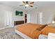 Comfortable main bedroom featuring a ceiling fan, flat screen television, and wood-look floors at 1913 Lazy Oaks Loop, St Cloud, FL 34771