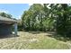 View of home backyard with grass and a few trees and plants with some shade from trees at 1947 Vienna Ave, Deltona, FL 32725