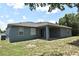 Photo of backyard with screened in porch and some grass area with a few trees in the background at 1947 Vienna Ave, Deltona, FL 32725