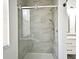 Bathroom featuring glass enclosed shower with bronze shower head and neutral tile surround at 1947 Vienna Ave, Deltona, FL 32725