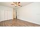 Bedroom featuring ceiling fan, closet, wood look flooring, white walls and trim at 1947 Vienna Ave, Deltona, FL 32725