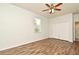 Bedroom with ceiling fan, closet, window with blind, wood-look flooring, and white walls at 1947 Vienna Ave, Deltona, FL 32725