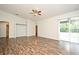 Spacious living area featuring wood floors, neutral walls, ceiling fan, and sliding glass doors at 1947 Vienna Ave, Deltona, FL 32725