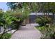 Brick walkway leading to the screened-in pool surrounded by lush landscaping at 2009 Woody Dr, Windermere, FL 34786
