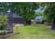 Large grassy backyard with a screened-in pool enclosure and mature trees at 2009 Woody Dr, Windermere, FL 34786