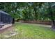 Spacious backyard with lush green grass and a backdrop of mature trees and a screen enclosed porch at 2009 Woody Dr, Windermere, FL 34786