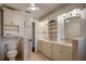 Bright bathroom with a double vanity, built-in shelving, and travertine flooring at 2009 Woody Dr, Windermere, FL 34786