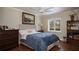 Cozy bedroom featuring a queen-size bed, wood floors, and a sunlit window at 2009 Woody Dr, Windermere, FL 34786