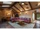 Cozy living room with a brick accent wall, skylights, wood beams, and a comfortable leather couch at 2009 Woody Dr, Windermere, FL 34786