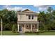 Charming two-story home with a covered front porch and lush, green landscaping at 2159 Stake Out Way, Apopka, FL 32703