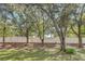 Wide view of the backyard with a pristine white fence and mature trees at 221 Sterling Springs Ln, Altamonte Springs, FL 32714
