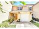 Charming two-story townhome featuring a one car garage and a welcoming front entrance with manicured landscaping at 221 Sterling Springs Ln, Altamonte Springs, FL 32714