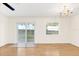 Bright living room with hardwood flooring, ceiling fan, chandelier, and sliding glass doors to the backyard at 221 Sterling Springs Ln, Altamonte Springs, FL 32714