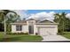 Well-maintained single-story home with a two-car garage, manicured lawn, and lush landscaping at 2234 Crown Rock Dr, Haines City, FL 33844