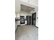 Spacious kitchen featuring modern appliances, tiled floor, and connecting room in background at 2235 Silver Pines Pl # 401, Orlando, FL 32808