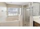 Bright bathroom showcasing a soaking tub and a walk-in shower with a frameless glass door at 2407 Accord Ter, Kissimmee, FL 34758