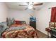 Warm bedroom with dark hardwood floors, a fan, and a large paisley bed at 2407 Accord Ter, Kissimmee, FL 34758