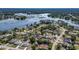 This is an aerial view of the area with many houses surrounded by lush landscaping and nearby lake at 2562 Sheffield Dr, Deltona, FL 32738