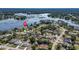 This is an aerial view of the area with many houses surrounded by lush landscaping and nearby lake at 2562 Sheffield Dr, Deltona, FL 32738