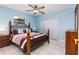 Blue bedroom with a wooden bed frame, ceiling fan, and tile flooring at 2562 Sheffield Dr, Deltona, FL 32738