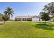 A well-kept lawn surrounds this single-story home with a two-car garage and lush trees at 2562 Sheffield Dr, Deltona, FL 32738