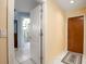 Hallway view leading to a bathroom featuring marble tile, and a glass block shower at 2562 Sheffield Dr, Deltona, FL 32738