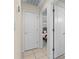Bright hallway with white doors, tiled floor, and view into a bedroom at 2562 Sheffield Dr, Deltona, FL 32738