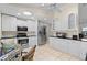 Open kitchen with stainless appliances, white cabinets, and a sunlit breakfast area at 2562 Sheffield Dr, Deltona, FL 32738
