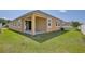 Backyard featuring a covered patio with sliding glass doors and green grass at 2598 Trielle Ave, Kissimmee, FL 34741