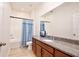 Bright bathroom featuring a granite countertop, wooden cabinets, and shower-tub combination at 2598 Trielle Ave, Kissimmee, FL 34741