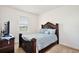 This bedroom features carpet, a large window, and an elegant dark wood bed frame at 2598 Trielle Ave, Kissimmee, FL 34741