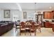 Open dining room with chandelier, wooden table set, and view of living room at 2598 Trielle Ave, Kissimmee, FL 34741