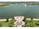 Aerial view of a lakeside fire pit area with seating and a water fountain in a residential community at 2598 Trielle Ave, Kissimmee, FL 34741
