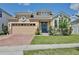 Charming home with a brick driveway, two car garage, and well manicured lawn at 2598 Trielle Ave, Kissimmee, FL 34741