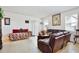 Comfortable living room with large window, sliding glass door, and leather reclining sofa at 2598 Trielle Ave, Kissimmee, FL 34741